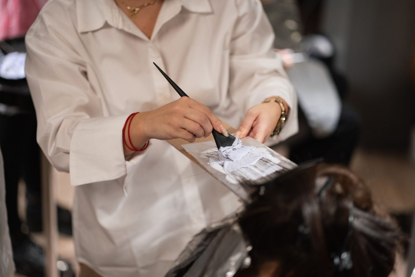 Licensed stock photograph: a stylist painting color onto a foil.
