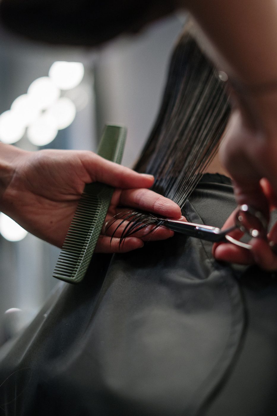 Licensed stock photograph: a comb and shears working through a wet section of hair.